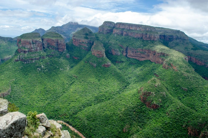 a view of a lush green valley with mountains in the background